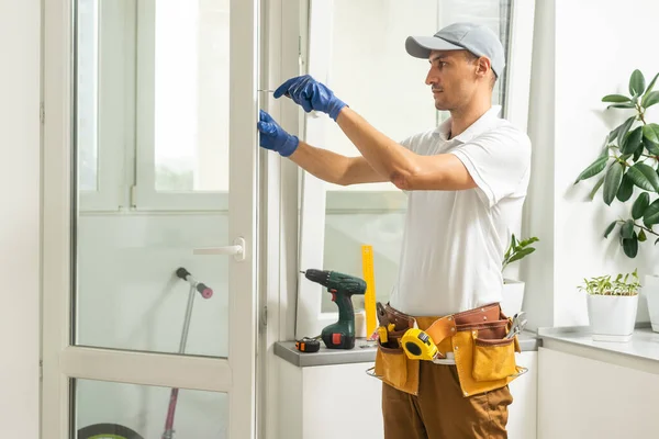 a repairman repairs, adjusts or installs metal-plastic windows in the apartment. glazing of balconies, loggias, verandas in house. production of double-glazed windows to individual sizes