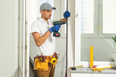 Eldivenlerde uzman. PVC pencerelerini tornavidayla kapatıyor. Plastik pencere onarım ve bakım konsepti kurulumu