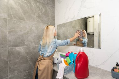 Güzel genç bayan banyoyu temizliyor..