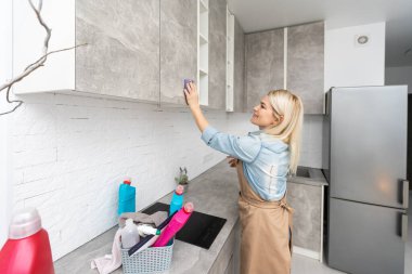 Neşeli genç profesyonel paslanmaz çelik evye mutfak temizlik önlük giyen temizlikçi.