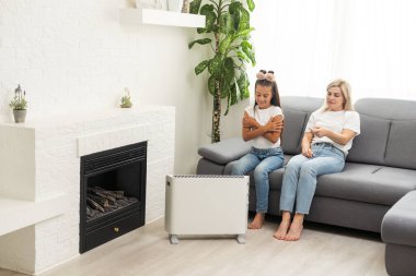 Family warming up near home heater at winter cold time. The symbolic image of the heating season at home
