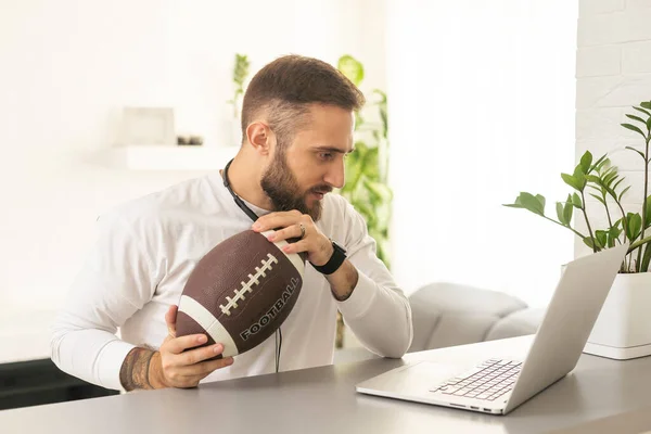 Happy man with laptop after winning his sports bet at home.