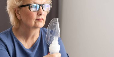 Astım spreyi olan yaşlı bir kadının yakın çekimi..