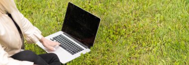 Bilgisayarlı bir kadın parkta dinleniyor..