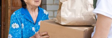 Yaşlı bir kadın için yemek dağıtan adam..