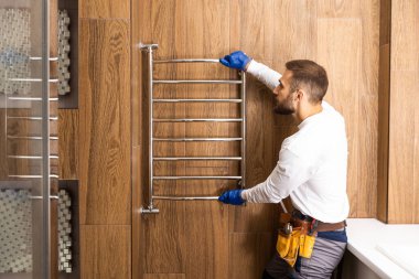 Plumber hanging towel rail. worker.