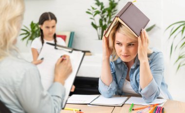 Konuşmak anlamanın anahtarıdır. Ebeveyn ve çocuk psikoloğu birlikte görüyor. Danışman terapist ve anne okul haberlerini paylaşan, hikaye anlatan ve soruları cevaplayan reşit olmayan kızları dinliyor.