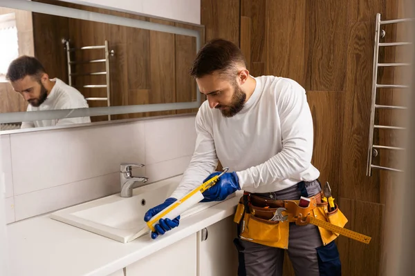 a worker installs a wash basin in a bathroom