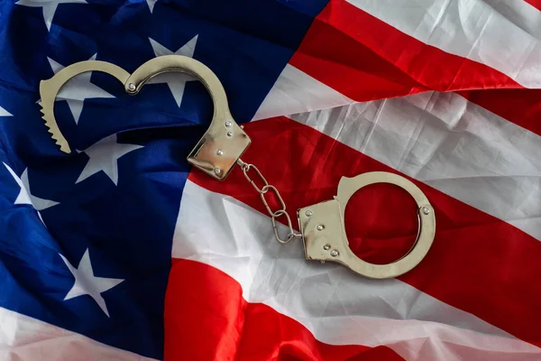 Police handcuffs on the USA flag, close-up,