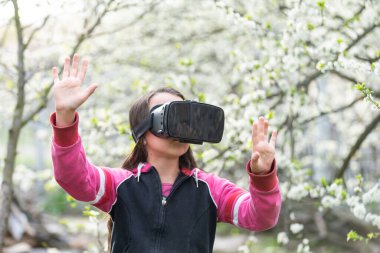 Sanal gerçeklik kulaklığı olan bir çocuk evde doğal hayatın arkasında oturuyor.