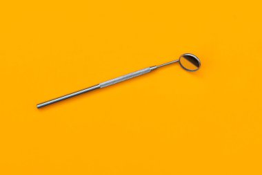 Turuncu arka planda diş aynası.