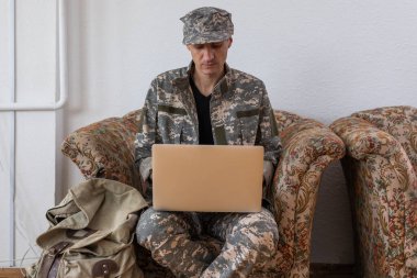 Asker holding laptop. Askeri eğitim kavramı.