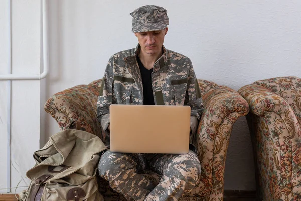 Soldier holding laptop. Military education concept.