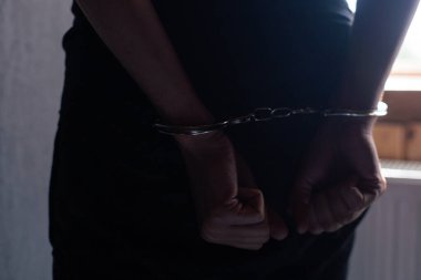 Erkek elleri kelepçeli siyah arka plan.