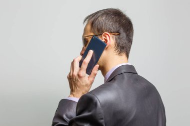 Gri arka planda duran havalı iş adamı