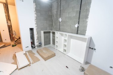 Mobilya yerleştirme ve montaj konsepti. İçinde mobilya olan bir karton kutuyu açıyorum. Dairenin sahibine ait yeni mobilyalar montajı