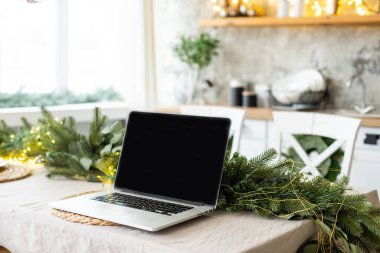 bilgisayar hediye kutusu ve yılbaşı ışıkları arka planında.