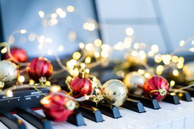 Piyano tuşlarının üzerinde renkli bir ışık zinciri yatıyor..