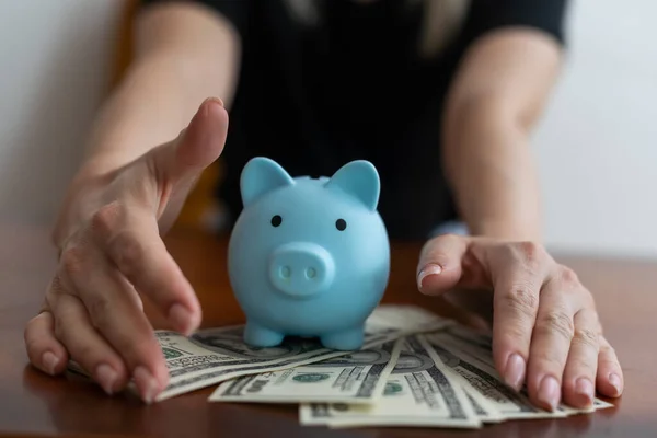 a woman keeps money in a piggy bank.