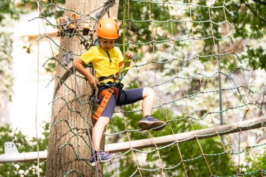Sevimli küçük kız macera Parkı sıcak ve güneşli yaz gününde tırmanma içinde onun zaman zevk.