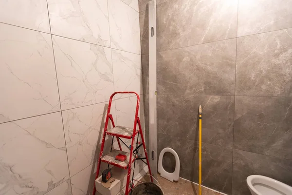 bathroom renovation and tiling. Laying floor ceramic tile.