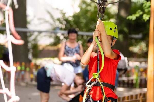 Boy climber walks on the rope bridge