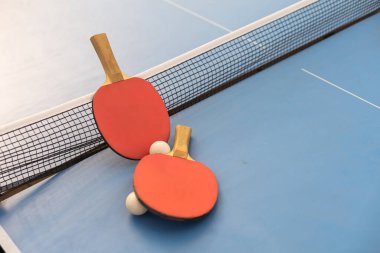 Ping pong table, rackets and balls.
