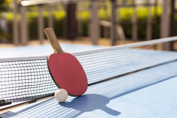 Ping pong table, rackets and balls.