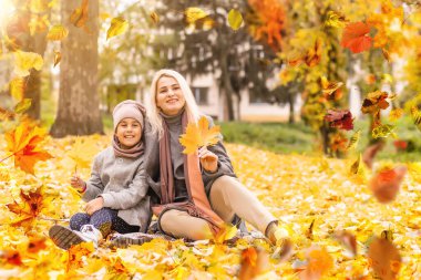 happy family: mother and child little daughter play cuddling on autumn walk in nature outdoors. High quality photo
