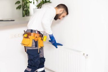 man repairing radiator with wrench. Removing air from the radiator.
