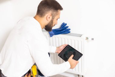 man repairing radiator with wrench. Removing air from the radiator.