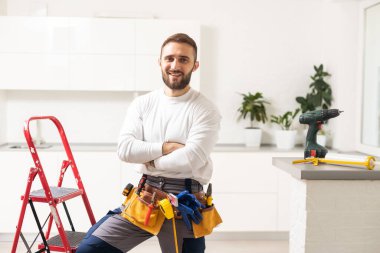 Male Worker Sitting on the Ladder on Construction Site. Repair Home and House Renovation Service.