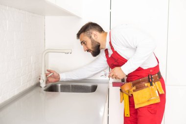 Genç tamirci mutfak lavabo musluk mutfak Room yükleme.