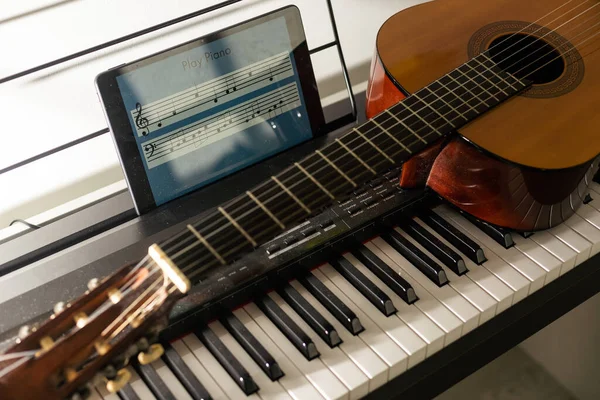 piano keyboard and guitar. tablet.