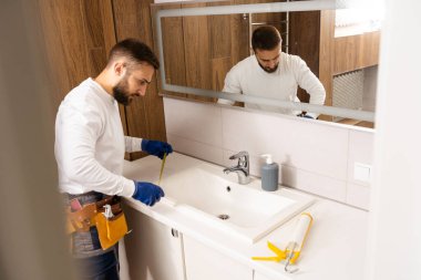a worker installs a wash basin in a bathroom