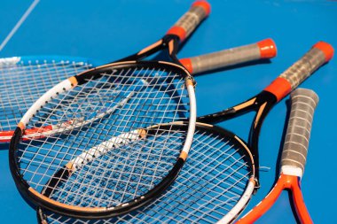 broken tennis rackets on clay tennis court.