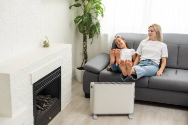 Aile eller elektrikli ısıtıcı üzerinde ısınmak.