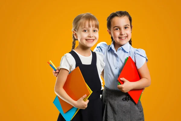 Little girls with books on orange background.