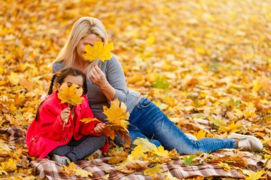 Sonbahar parkında yürüyen sevimli bir aile. Anne ve küçük kızı.