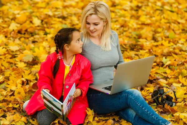 행복한 어머니와 아이가 공원에서 책이나 태블릿 Pc를 — 스톡 사진