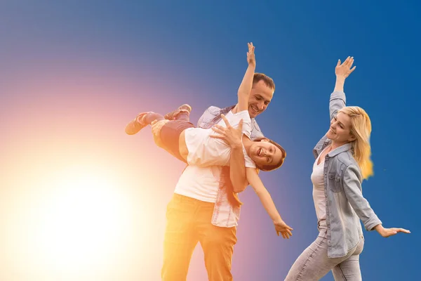 funny young parents mom dad with child kid daughter teen girl isolated on blue background. Family day parenthood concept.