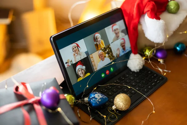 Christmas video call with happy family. Concept of families in quarantine during Christmas because of the coronavirus. Xmas still life with a tablet in a cozy room.