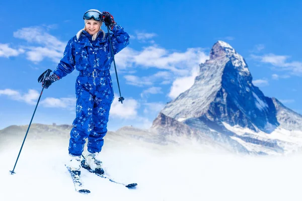 female wearing sports jacket and goggles who hands skis.