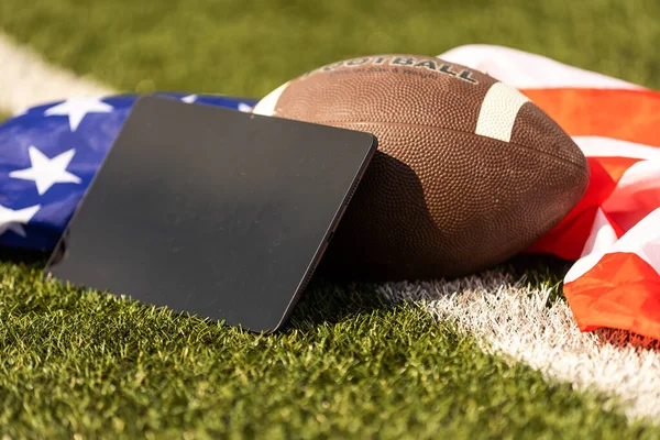 american football ball and tablet, american flag.