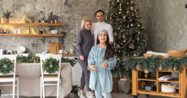 Evdeki güzel Noel ağacı. Aileler sevimli kızlarına hediye paketi sunuyor.