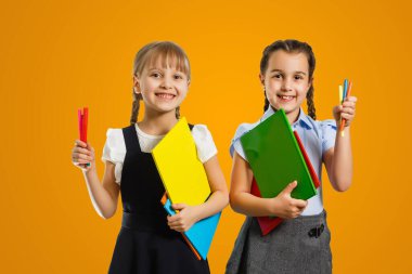 Little girls with books on orange background.