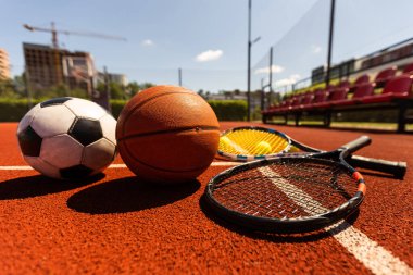 Set of sport equipment, rackets and tennis balls soccer and basketball balls.