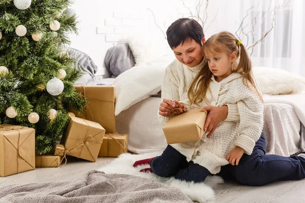 家族および人々 のコンセプト 幸せな母親とかわいい女の子のギフト ボックス クリスマス ツリーとリビング ルームの背景の上で — ストック写真