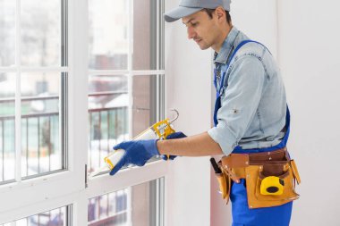 İnşaat işçisi eve pencere kuruyor.