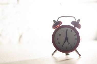 Retro alarm clock with seven oclock. Old style filtered photo.
